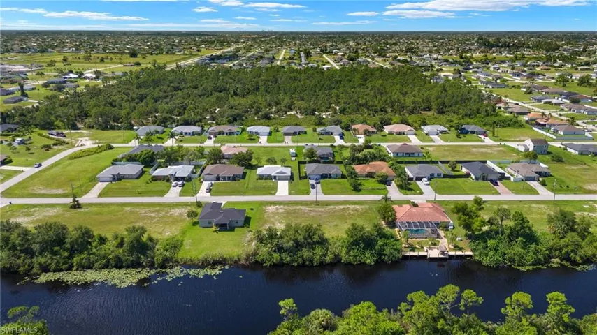 Birds eye view of property with a water view