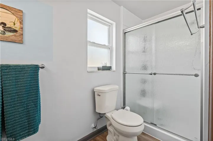 Bathroom featuring a shower stall and wood finished floors