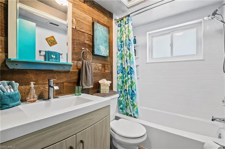 Bathroom with vanity and shower / bath combination with curtain
