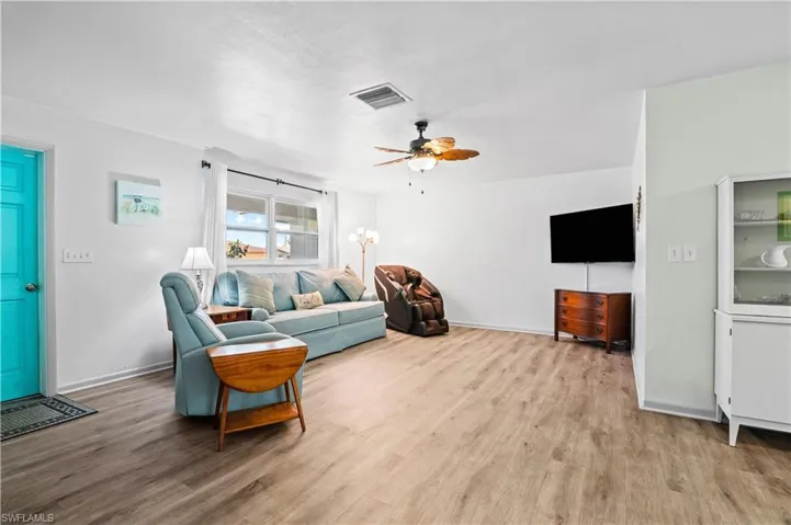 Living room featuring light wood-type flooring and ceiling fan