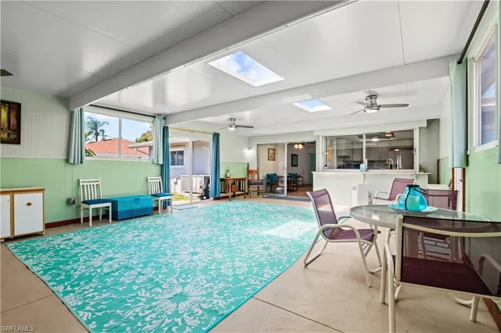 View of swimming pool with ceiling fan, a skylight, and a sunroom