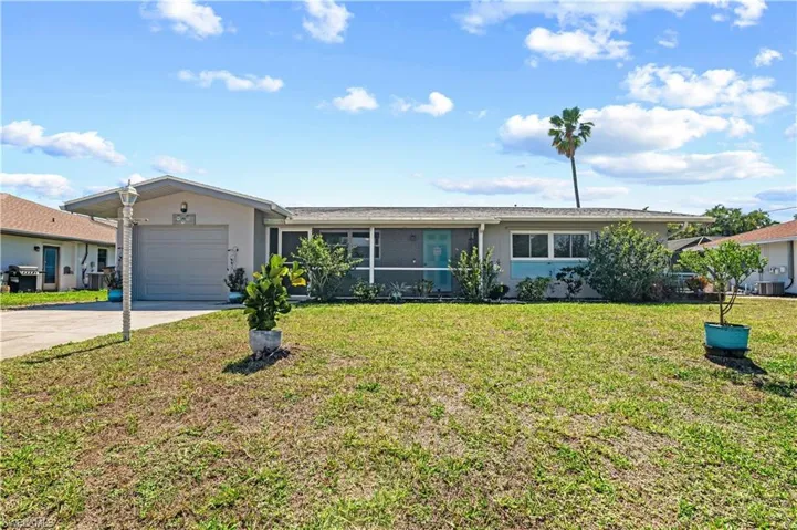 Single story home featuring a front lawn, concrete driveway, a garage, and stucco siding