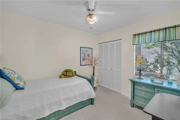Bright interior space featuring a window with integrated blinds, a bi-fold closet, and a ceiling fan with integrated lighting
