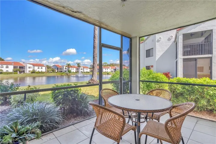 Covered lanai with floor-to-ceiling windows framing waterfront and community vistas