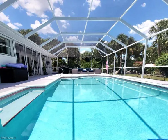 View of pool with a patio and glass enclosure