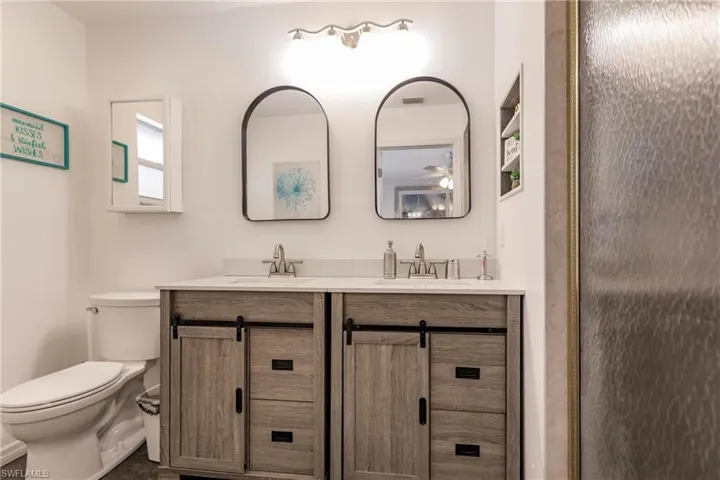 Bathroom with dual sinks, toilet, and large vanity