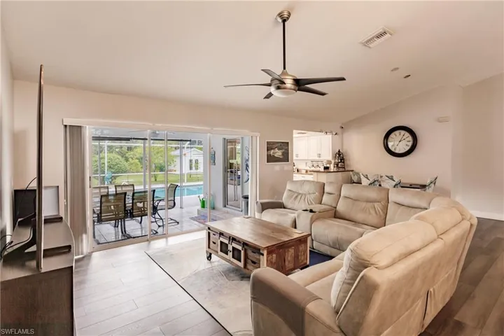 Living room featuring hardwood / wood-style flooring, lofted ceiling, and ceiling fan