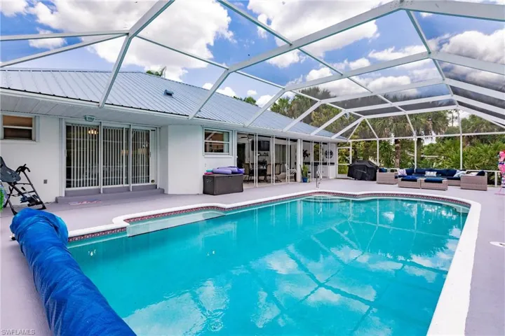 View of pool with a grill, a patio, an outdoor living space, and a lanai