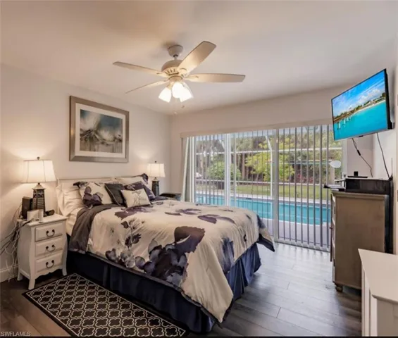 Bedroom with dark wood-type flooring, ceiling fan, and access to exterior