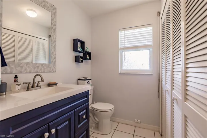 Bathroom with tile flooring, vanity, and toilet