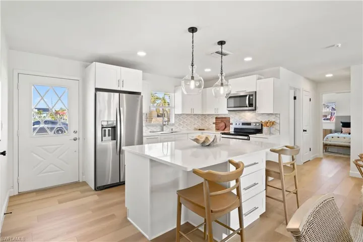 This kitchen features modern appliances and quartz countertops with an island.