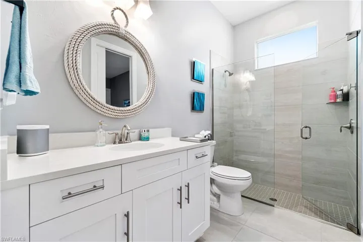 Bathroom with vanity, an enclosed shower, and toilet