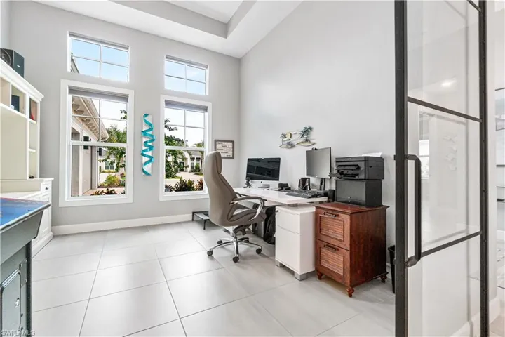 Office area with light tile patterned floors and a high ceiling