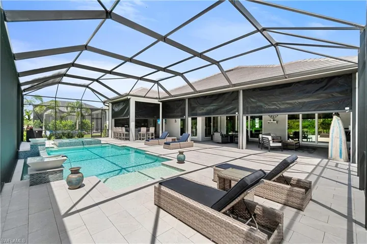 View of swimming pool with a patio area, an outdoor living space, and glass enclosure