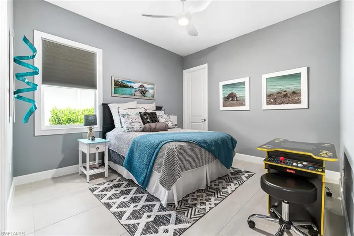 Tiled bedroom featuring ceiling fan