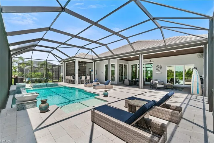 View of pool featuring a patio, an in ground hot tub, a lanai, and outdoor lounge area