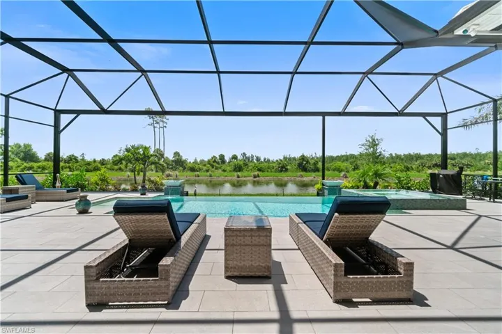 View of pool featuring a water view, a patio, and a lanai