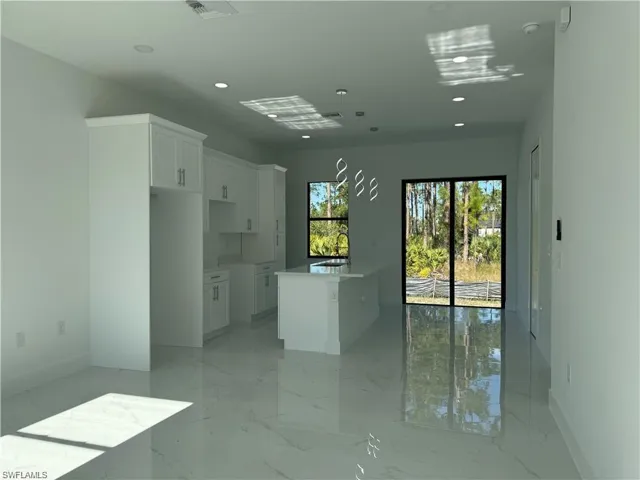 Kitchen featuring white cabinetry, sink, and a kitchen island