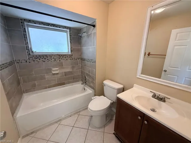 Bathtub with tile surround, mosaic accent tile, and frosted window