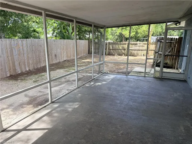 Screened patio with a concrete floor, surrounded by wood fencing