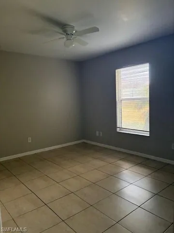 Spare room with light tile patterned flooring and a ceiling fan