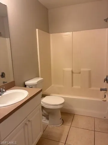 Full bathroom with vanity, shower / bath combination, and light tile patterned flooring
