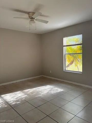 Unfurnished room featuring light tile patterned floors and ceiling fan