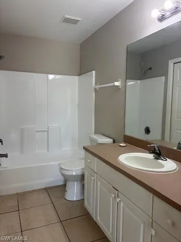 Full bathroom featuring vanity, washtub / shower combination, and light tile patterned floors