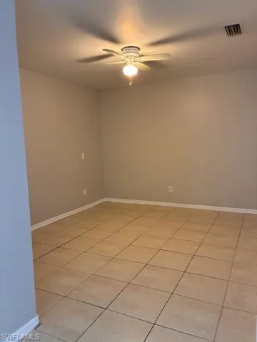 Unfurnished room with light tile patterned floors and a ceiling fan
