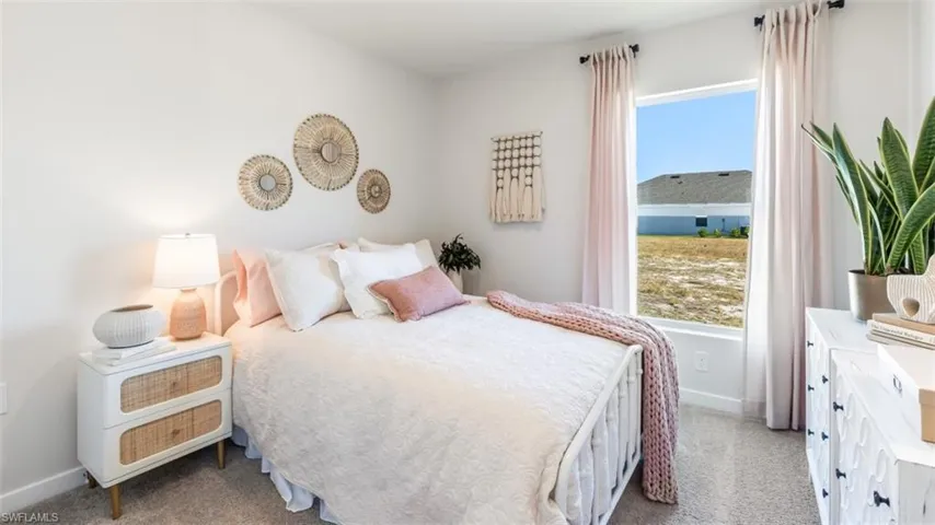 Model home. Bedroom with baseboards and light carpet