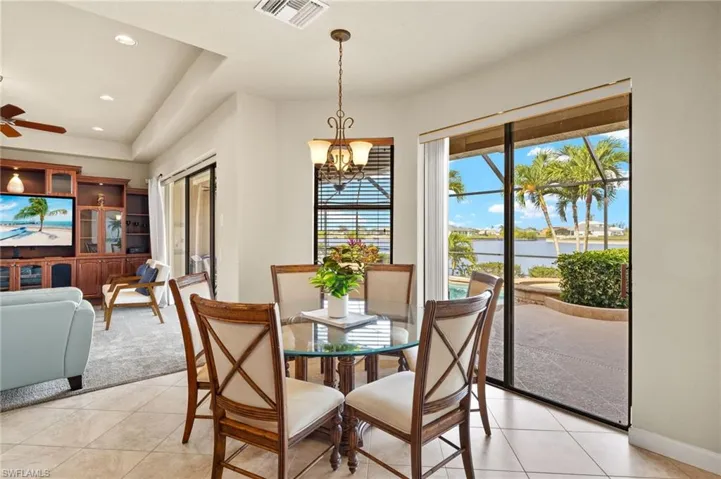 Dining space featuring plenty of natural light, a water view, light tile patterned floors, a chandelier, and recessed lighting
