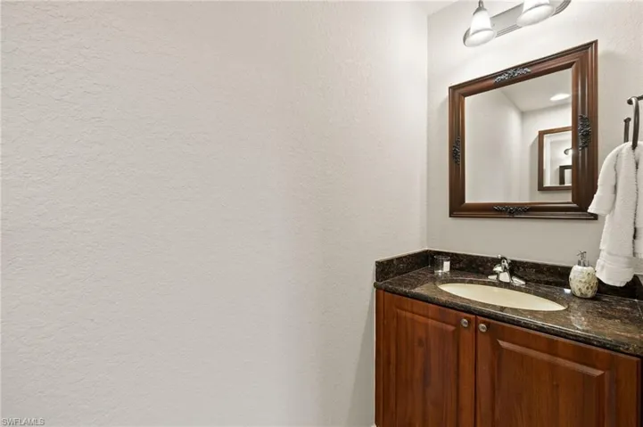 Bathroom featuring vanity and a textured wall