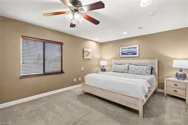 Carpeted bedroom with baseboards and a ceiling fan