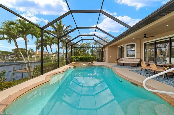 View of pool featuring outdoor lounge area, a patio area, a pool with connected hot tub, a ceiling fan, and a lanai