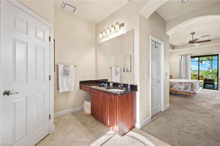 Bathroom with baseboards, vanity, ensuite bathroom, a ceiling fan, and tile patterned flooring