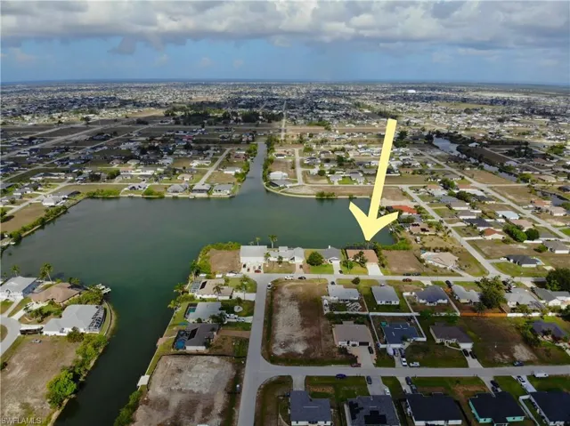 Aerial view of property and surrounding area with nearby suburban area and a nearby body of water