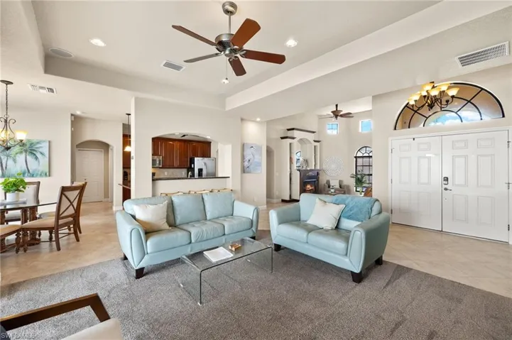 Living area featuring arched walkways, a chandelier, a ceiling fan, and recessed lighting