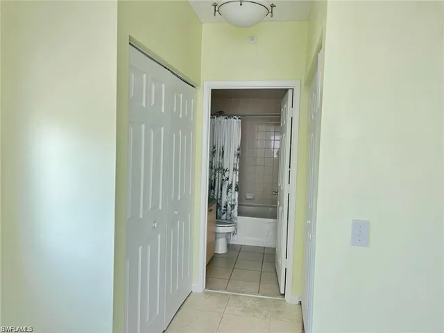Hall with light tile patterned flooring