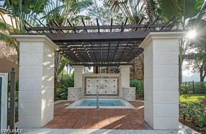 View of property's community with a pergola, a patio area, and a jacuzzi
