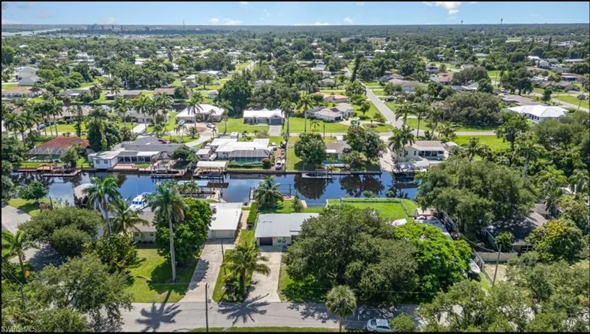 Aerial view of property and surrounding area with a large body of water and nearby suburban area