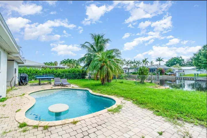View of pool featuring a patio, a fenced backyard, and grilling area