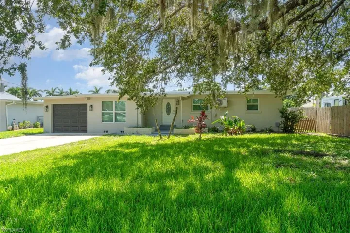 Ranch-style home with a garage, driveway, and stucco siding