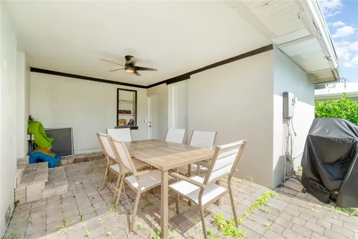 View of patio with ceiling fan, outdoor dining space, and grilling area