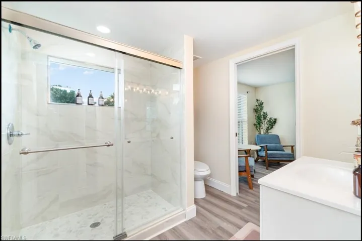 Full bath featuring a stall shower, wood finished floors, and vanity