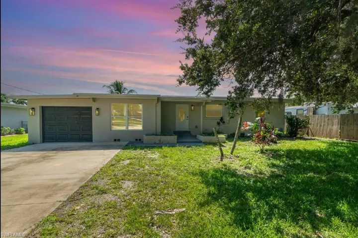 Single story home featuring stucco siding, an attached garage, and driveway