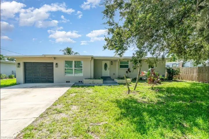 Ranch-style home with concrete driveway, an attached garage, and stucco siding