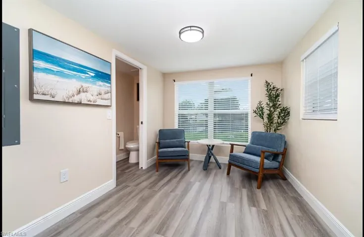 Sitting room with light wood-style floors and baseboards