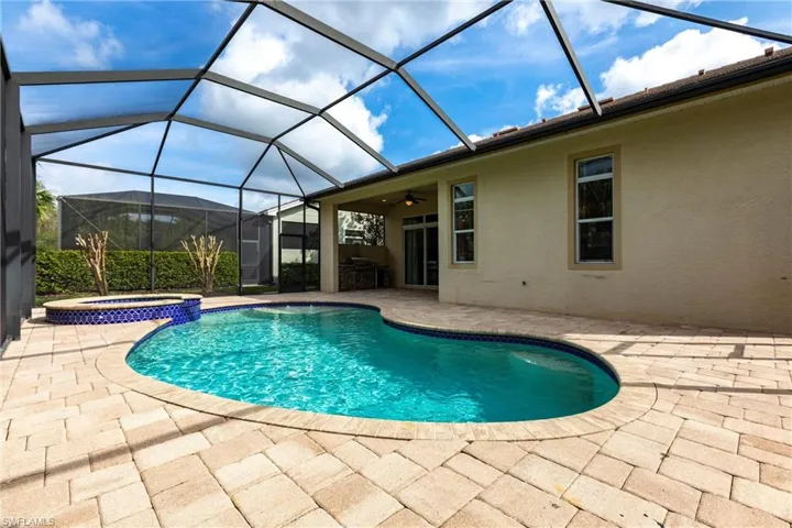 View of pool with a pool with connected hot tub, a lanai, and a patio
