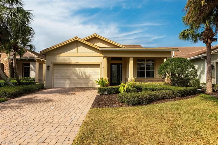 Ranch-style house with a garage, a front yard, decorative driveway, and stucco siding