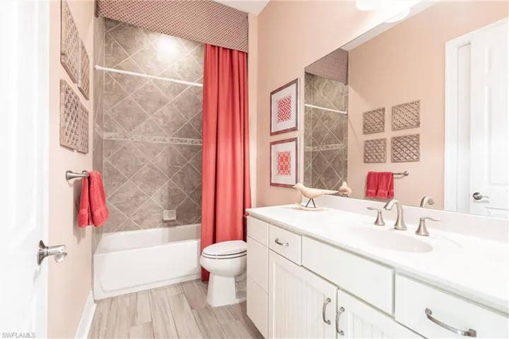 Bathroom featuring shower / tub combo, vanity, and toilet